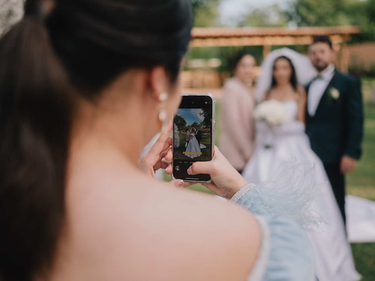 Wedding guest photographing the couple with a smartphone